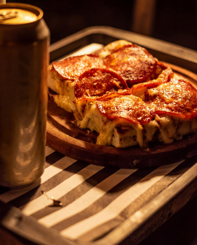 Pizza de pepperoni con queso fundido y una lata, en una bandeja